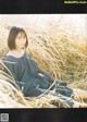 A woman sitting in a field of tall grass.