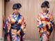 A woman in a colorful kimono posing for a picture.